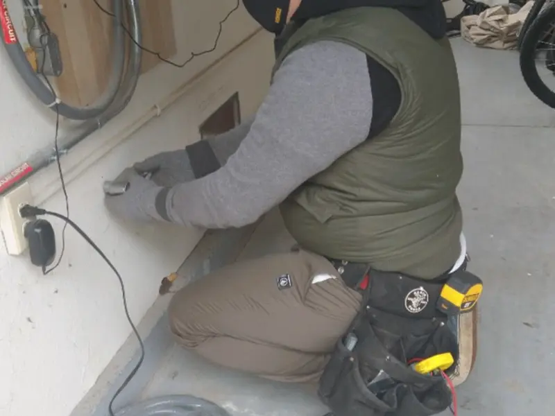 Electrician performing outlet wiring in a Destin garage